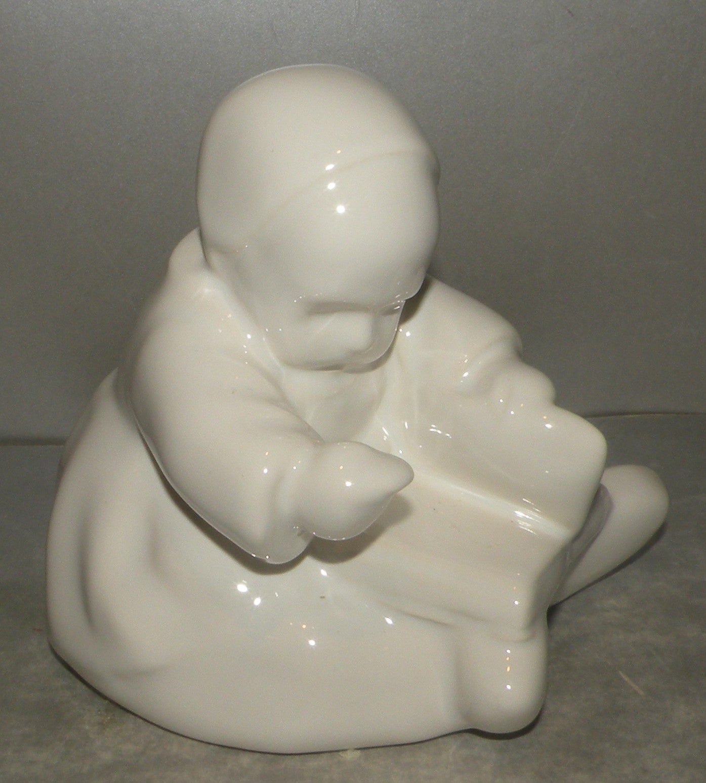 Baby with a book, white enamel- by Berthe Savigny, HB-Henriot